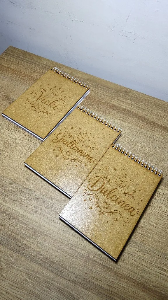 Anotadores anillados grabados con nombres y una corona