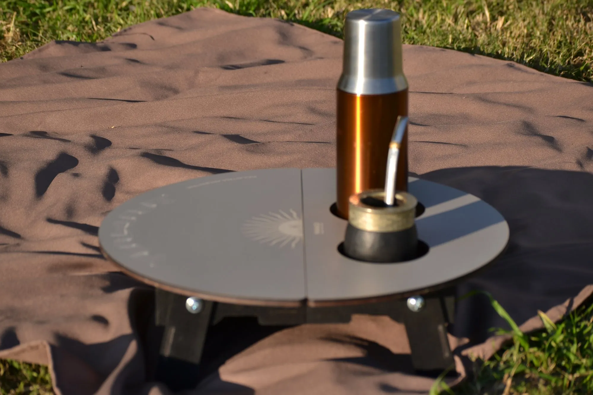 Mesa matera de Manadi en el pasto, con mate y termo
