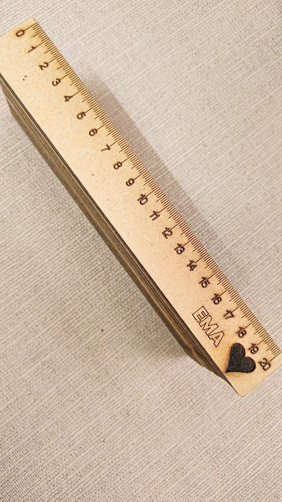 Reglas de madera grabadas con el nombre EMA y un corazón